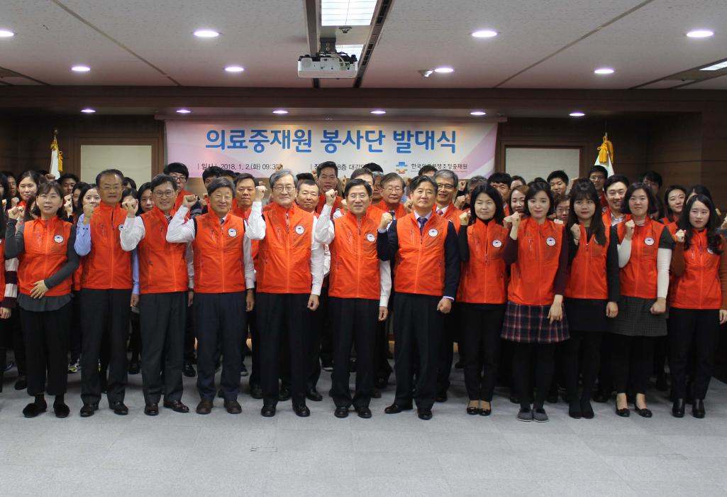 의료중재원 봉사단 발대식 플랜카드 앞에서 화이팅 포즈를 취하는 봉사단